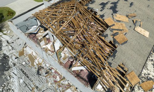 Damaged house roof and walls after hurricane Ian in Florida. Consequences of natural disaster.